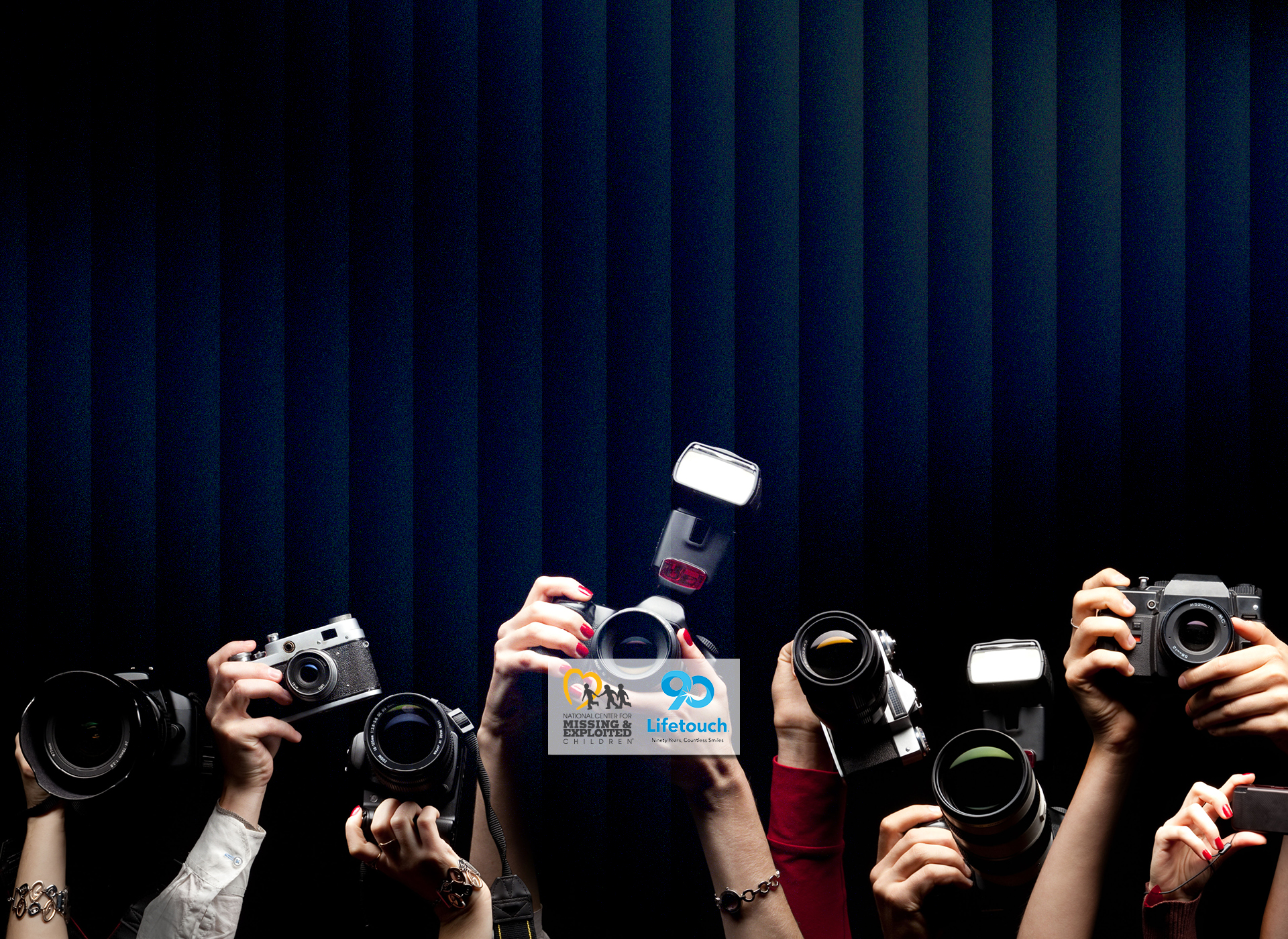 a bunch of hands holding up cameras