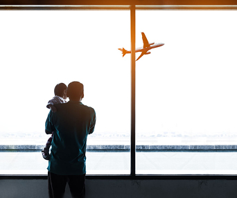 parent and child watch airplane fly away airport